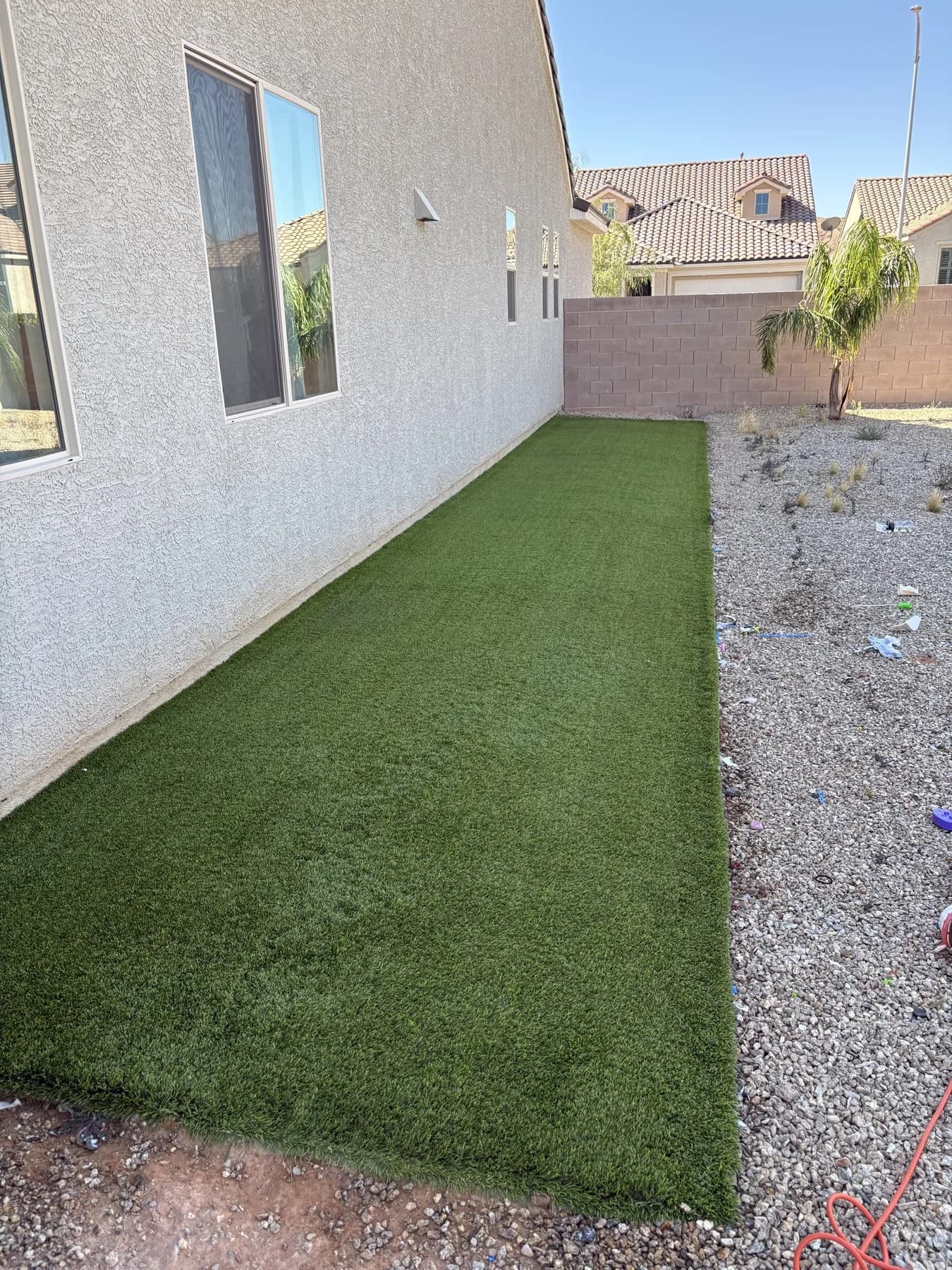Vibrant restored artificial turf in the same backyard after deep cleaning and infill top-off